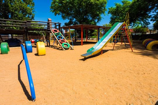 The Colorful Slides And Swings On The Playground In A Park