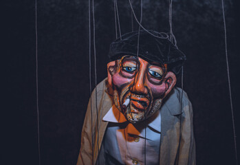 A closeup of a hand made realistic puppets on a black background