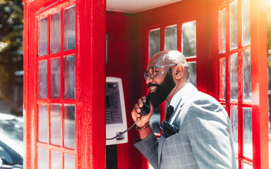 A cheerful mature bald elegant black man entrepreneur in a fashionable business costume,...