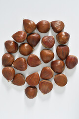 Un montón de castañas sobre fondo blanco.