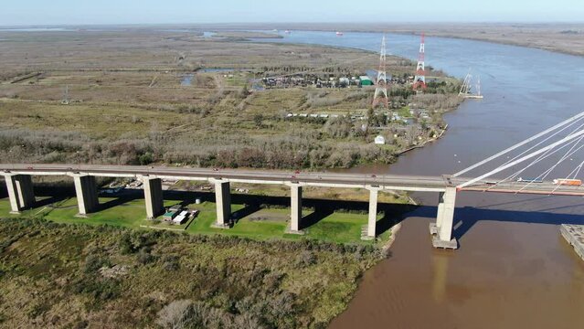 Vista a&eacute;rea de un extremo de un gran puente colgante, que cruza un r&iacute;o muy ancho y una vista general del ingreso.