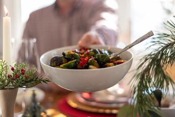 Passing vegetables across the table at a family dinner