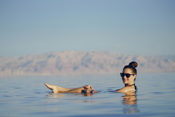 brunette girl swimming in the dead sea in israel
