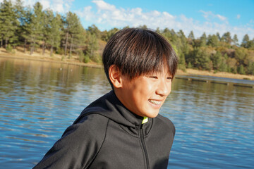 Portrait of young sporty Asian boy by the Lake. Teenager concept