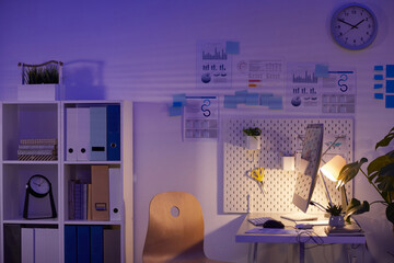 No people shot of convenient modern office workspace interior at night in lamp light, copy space