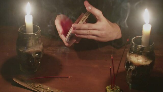 Close up of mysterious wizard male fortune teller shuffle the cards and prepare them to future telling