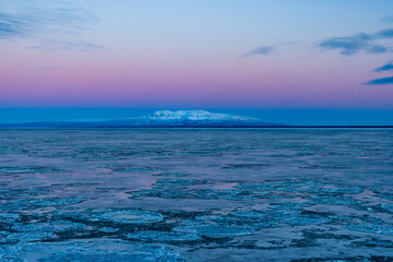 Obraz premium Mount Susitna just before dawn in winter, lit by the alpenglow (taken from Anchorage, Alaska)