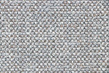 Sample of a gray fabric with a pronounced weave of threads. Textiles and wool. Blank background and close-up.
