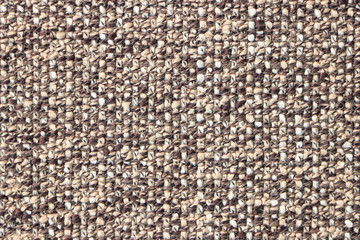 Sample of a beige brown fabric with a pronounced weave of threads. Textiles and wool. Blank background and close-up.