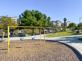 Swing at children playground activities in public park. swing on modern playground. Urban neighborhood childhood concept. 