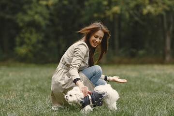 Fototapeta premium Woman in a brown coat. Lady with a labrador. Friends are having fun outside.