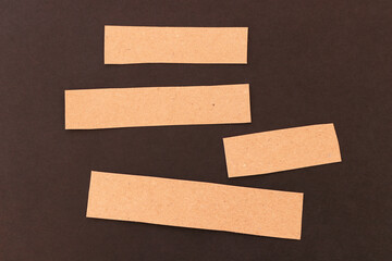 Blank craft cardboard strips for text on a black background.