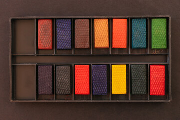 Old set of watercolors for painting on a black background. Close-up.