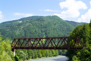 Fototapeta na wymiar Landscape with a river and a railway bridge. Old railway bridge in the Ukrainian Carpathians across the river