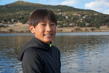 Fototapeta premium Portrait of young sporty Asian boy by the Lake. Teenager concept