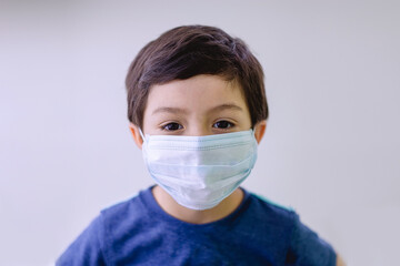 Niño latino con cubrebocas cuidado covid 10