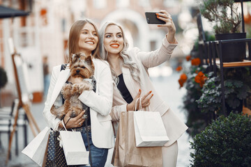 Ladies in a shopping. Woman with cute dog. Women with shopping bag.