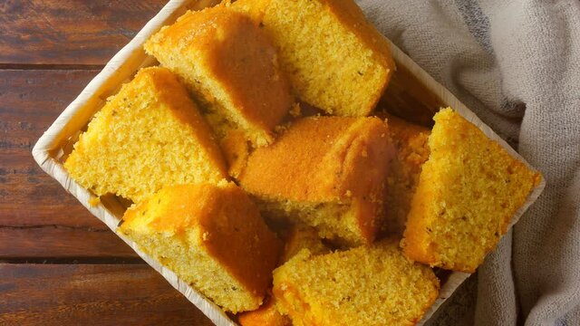 corn cake sliced in basket on rustic wooden table for breakfast. Typical Brazilian food