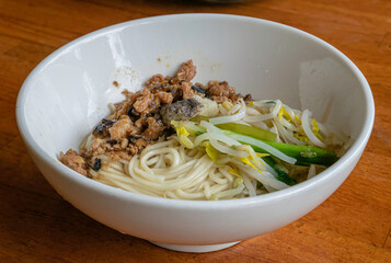 The close up of Taiwan homemade minced pork with mushroom sauce noodles,  Taiwanese traditional dry noodles food on wooden table.