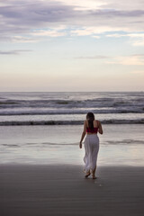 Mulher andando sozinha em direção ao Mar em praia vazia. Espaço para texto. 
