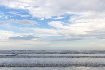 foto do mar, ondas, céu e nuvens. Espaço para texto. 