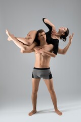 Fototapeta premium Shirtless male carrying young female on back