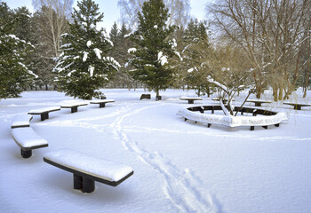 Benches in the winter Park. The round platform vacation among the snow drifts on the square of Fame