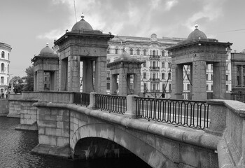 Fototapeta premium Lomonosov bridge over the Fontanka river. Granite tetrapylon with hanging iron chains, the fence of the bridge houses along the river, city center