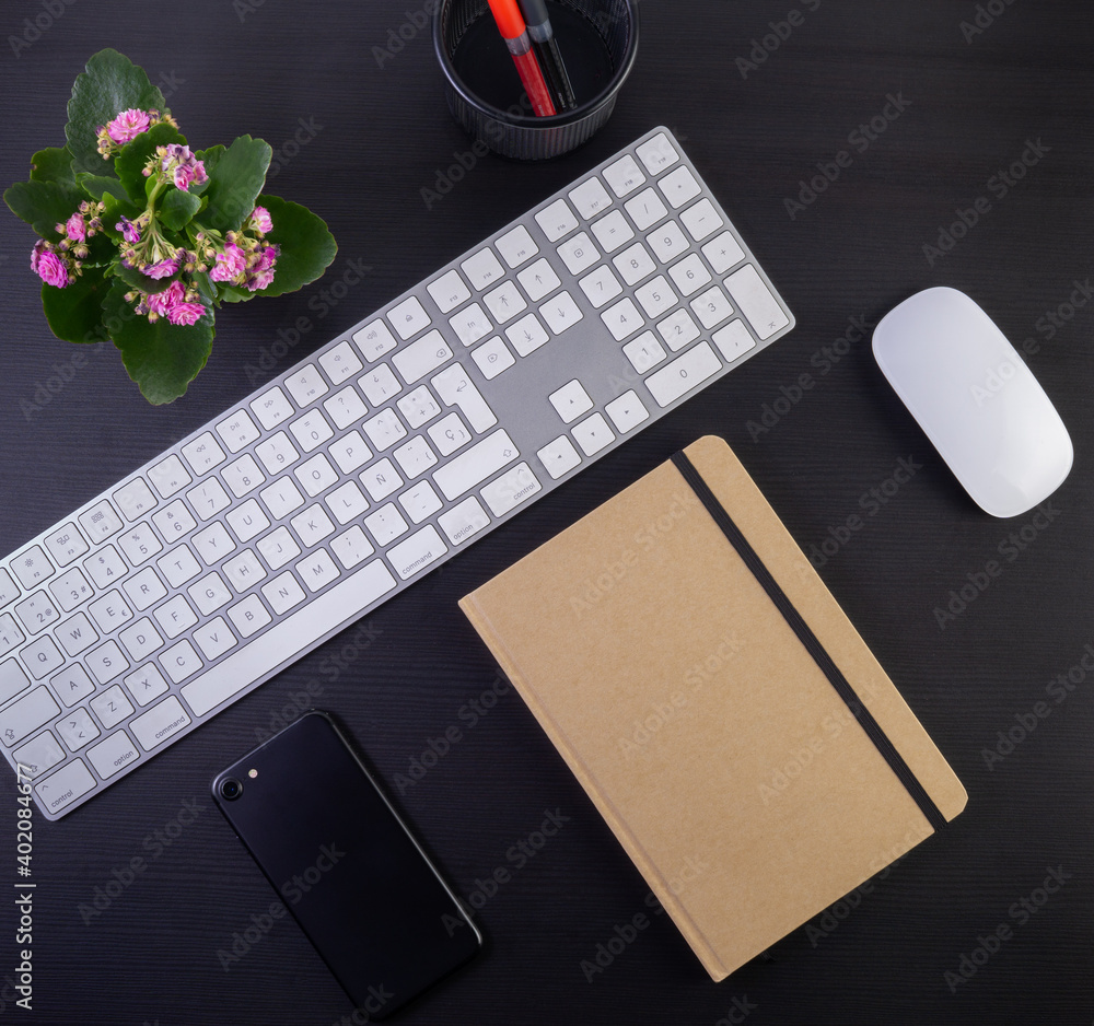Poster a top view of a work desk with a keyboard, notebook, computer mouse and a flower