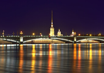 Obraz premium Night city. View of the Trinity bridge and Peter and Paul Cathedral in the night lights reflected in the waters of the Neva. Architecture of the XVIII century
