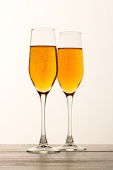 Two glasses of champagne, wine with bubbles on gray background. Alcoholic drink: champagne, beer, white wine. New year and Christmas background. Valentine's Day. Vertical