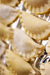 A top view closeup of Polish pierogi placed on tinfoil ready to be cooked