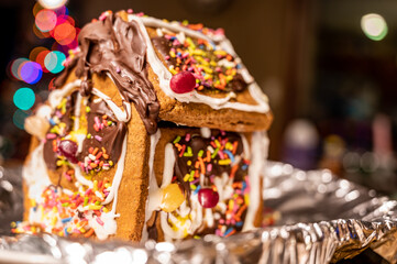 Fototapeta na wymiar Homemade gingerbread house with a blurred kitchen background