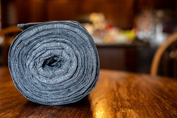 Roll of new kitchen garbage bags on wooden table