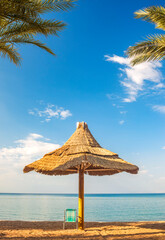 Summer seascape, nature of tropical beach with sunshade or umbrella and resting chair. Golden sand...