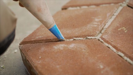 Laying paving stones, closing seams. Sealing paving joints with mortar. applying glue to the seams.