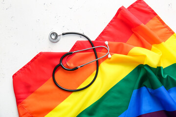 Stethoscope and rainbow LGBT flag on light  background