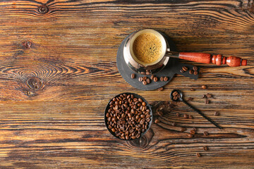 Pot with hot coffee on wooden background