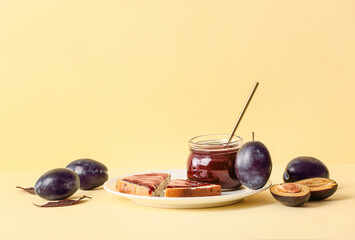 Composition with delicious homemade plum jam on light background