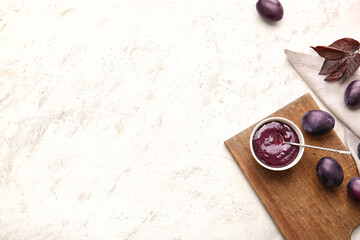 Bowl with delicious homemade plum jam on table