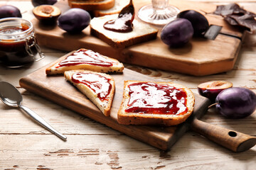 Slices of bread with delicious homemade plum jam on board