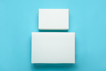 Blank cardboard boxes on color background