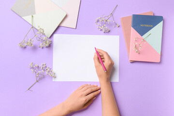 Female hands with blank paper sheet, notebooks and pen on color background