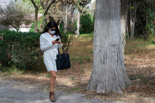 mujer joven de negocios caminando en el parque de la parroquia de santa mar&iacute;a magdalena en Tepetlaoxtoc texcoco