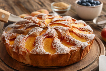 Tasty peach pie with knife, closeup