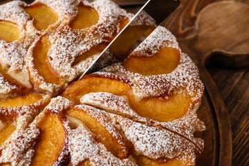 Tasty peach pie with knife, closeup