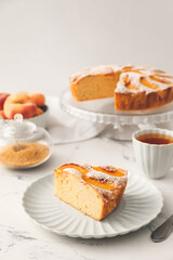 Plate with piece of tasty peach pie on table