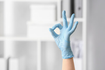Hand in protective glove showing OK, closeup