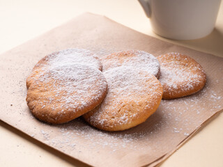 Delicious homemade shortbread cookies, in warm brown tones, close-up. Cookies in powdered sugar on a paper napkin