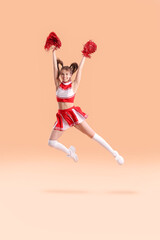 Fototapeta na wymiar Beautiful young cheerleader on color background